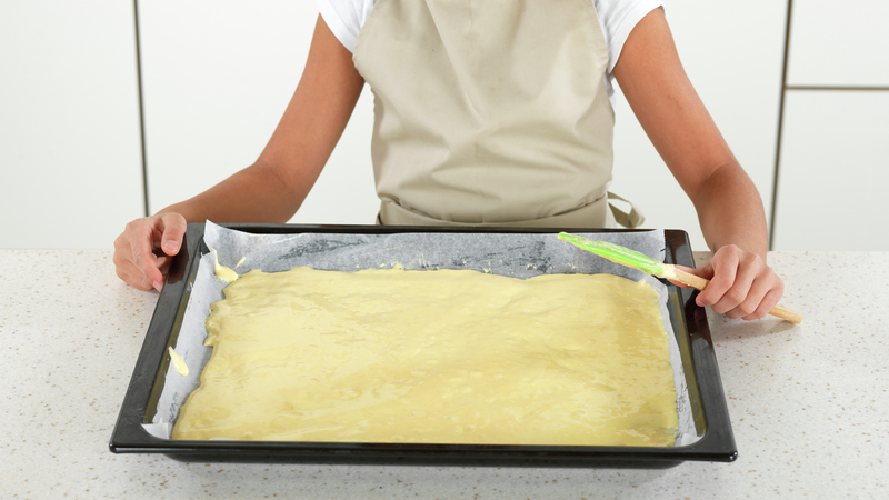 Ha røren over i langpannen og bruk slikkepotten til å fordele røren jevnt i langpannen. Det blir et ganske tynt lag, men kaken kommer til å heve i ovnen, slik at den blir større.