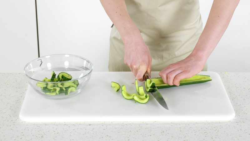 Skjær agurken i tynne skiver (halvmåner). Ha dem over i en skål eller en bolle.