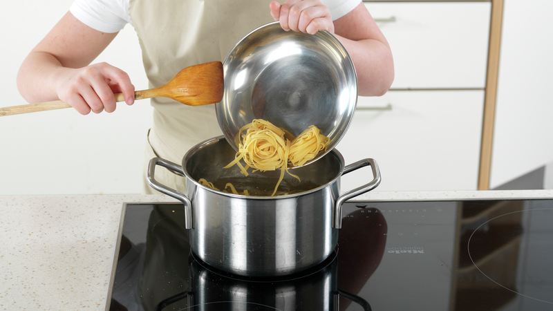 Ha pasta i det kokende vannet, og rør rundt med en sleiv. Skru ned varmen til middels, slik at det ikke koker over.