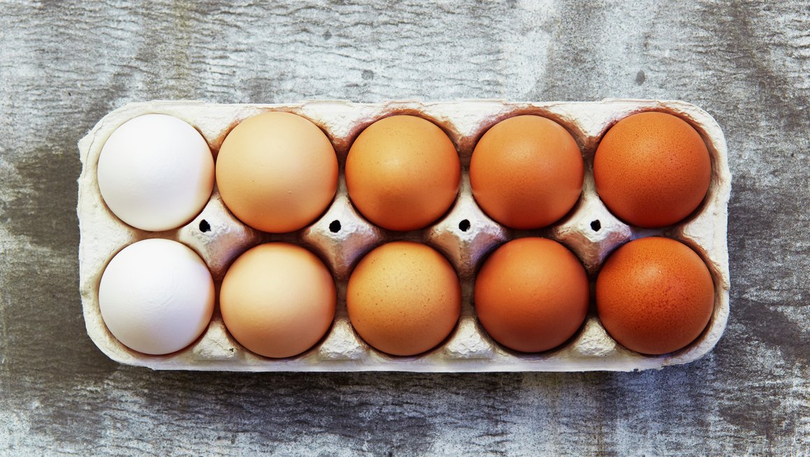 Hvite og brune egg i eggekartong