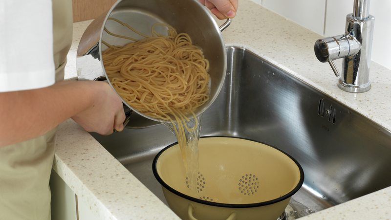 Skru av kokeplaten når pastaen er ferdig. Sett et dørslag på en tallerken i vasken. Hell pastaen i dørslaget, løft det opp og rist litt slik at alt vannet renner av. Ha pastaen tilbake i kjelen.