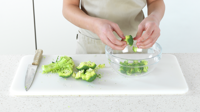 Mens risen koker kan du kutte grønnsaker. Skjær av den mengden brokkoli du trenger. Hvis den ikke er vasket fra før, må du gjøre det. Skjær brokkoli i små buketter. Ha i en bolle. Her kan du godt bruke hendene dine til å rive bukettene i små biter.