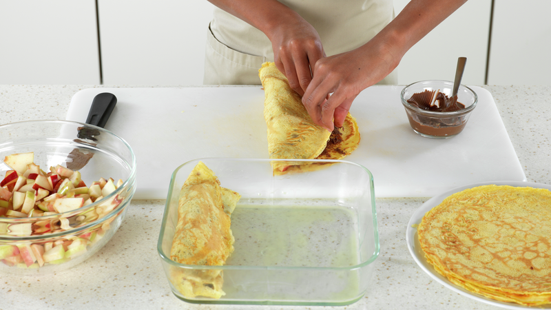 Brett pannekaken sammen, slik at fyllet blir pakket godt inn, og legg over i den ildfaste formen. Gjør det samme med resten av pannekakene.