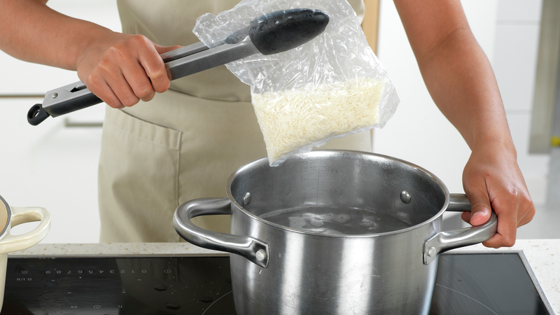 Når vannet koker: Bruk en klype og legg posene med ris i vannet. Kok dem så lenge det står på pakken. Skru ned til middels varme, slik at det ikke koker over.