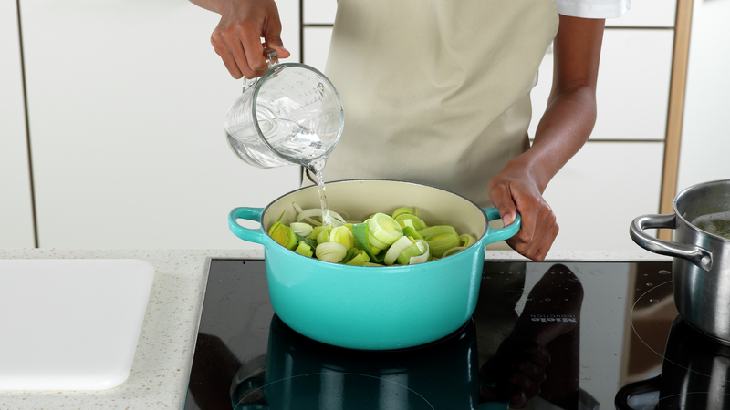 Ha purren i gryta, og hell på vann. Sørg for at kokeplaten står på full varme, for å få gryta til å koke. Bruk en sleiv til å blande alt sammen.