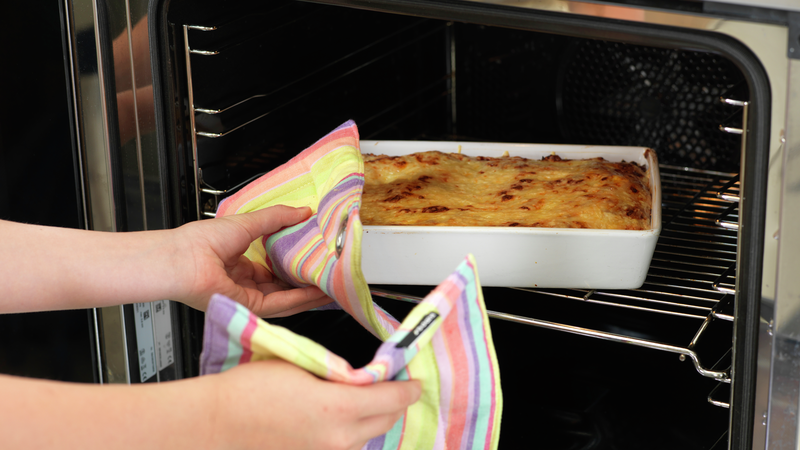 Finn frem et gryteunderlag eller noe du kan sette den ildfaste formen på. Bruk grytekluter og pass på slik at du ikke brenner deg når du tar formen ut av ovnen. La lasagnen hvile noen minutter før servering.