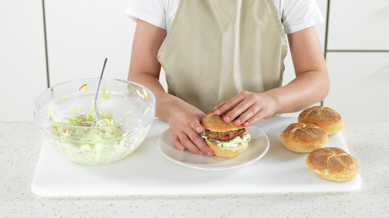 Legg brødet på toppen. Gjør det samme med resten av burgerne og fordel gjerne resten av kålsalaten på tallerkenene. Nå kan du rope at maten er klar!