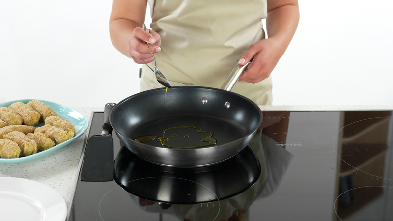 Sett frem en tallerken som du kan ha de stekte bollene på. Ha en stekepanne på stekeplaten og sett på middels varme. Ha i 1 ss olje når pannen er varm.