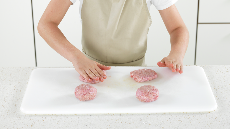 Rull hver porsjon til en ball og press hver ball litt flat, slik at det ligner en hamburger. Ikke glem god hygiene! Husk å vaske hender, kniv og skjærefjøl som har vært i kontakt med rått kjøtt.