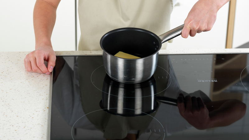 Mål opp smør og ha smøret i en liten kjele. Skru stekeplaten på middels varme og la smøret smelte.