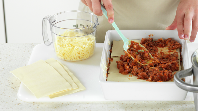 Start med å ha litt ostesaus i bunnen. Legg så over lasagneplater, og så kjøttsaus. Fortsatt å legg lag på lag, til du har brukt opp alt. Avlutt med et lag ostesaus.