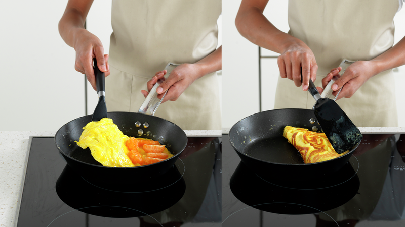 Bruk stekespaden til å brette den ene siden av omeletten over klementinbitene.