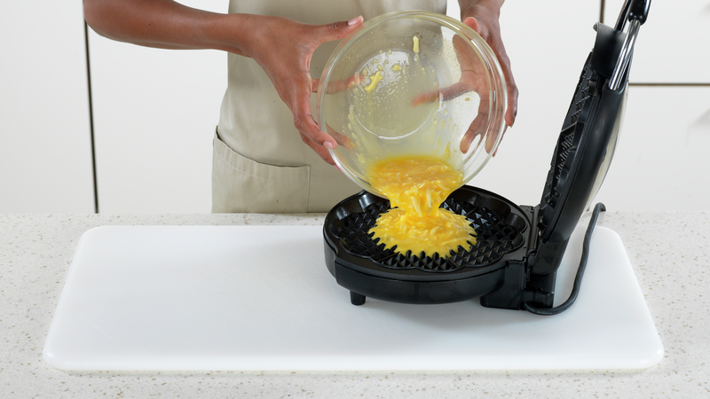 Hell røra over i vaffeljernet. Omelettvaffelen kommer til å vokse litt i størrelse, så ikke fyll det helt. Vaffeljern kommer i ulike størrelser, så her kan det hende du må prøve deg frem litt. Du kan alltids lage en liten omelett til av restene.