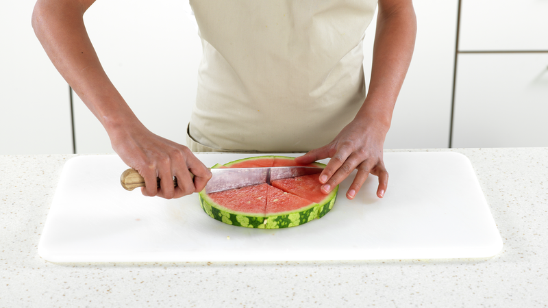 Du trenger en skive vannmelon som bunn. Få hjelp av en voksen til å skjære ut en skive vannmelon, da det kan være litt hardt arbeid. Skjær vannmelonskiven i 6 skiver.