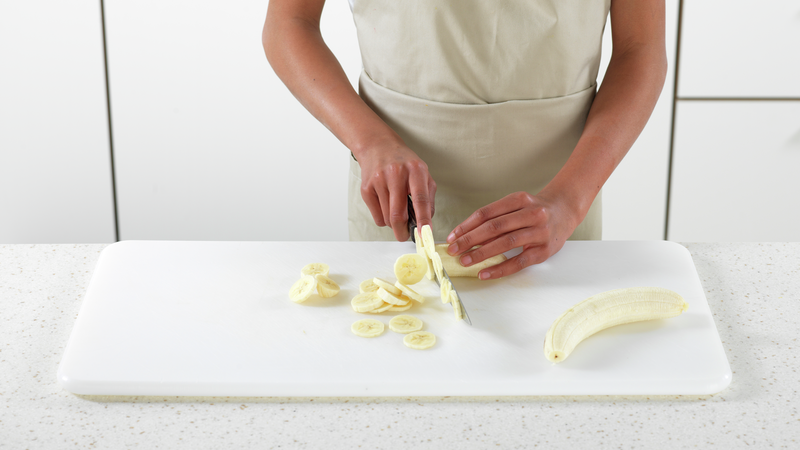 Skrell banan og kast skallet. Del bananen i tynne skiver og legg på en tallerken.