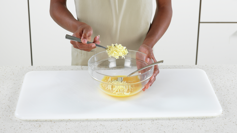 Mål opp ost og ha i bollen. Visp sammen blandingen med gaffelen.