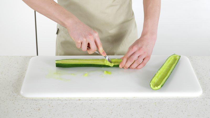 Start med å forberede salaten. Vask agurk. Del den i to på langs. Bruk en skje og skrap ut den myke kjernen. Kjernen skal du ikke bruke videre.