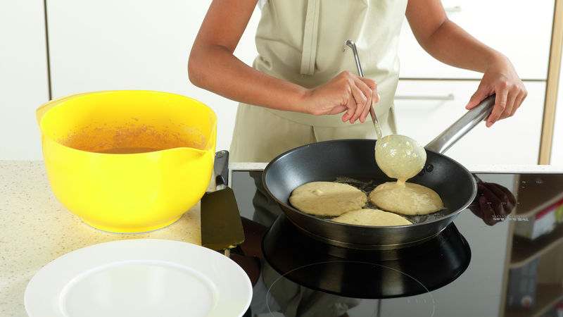 Bruk en øse og hell litt pannekakerøre i stekepannen, når smøret har sluttet å bruse. Her lager vi små pannekaker, så prøv å få plass til to eller tre i pannen samtidig.