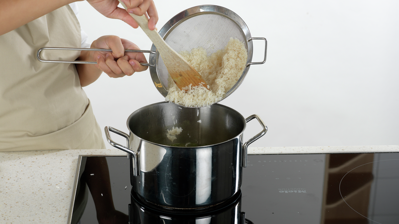 Når vannet koker, kan du ha i risen. Skru ned varmen til lav varme (ca. 2). Sett på lokk. La risen stå på platen i ca. 20 minutter.