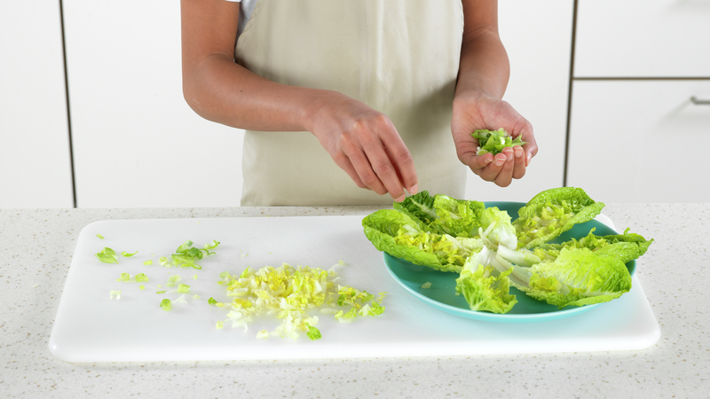 Fordel strimlet salat og vårløk på hvert salatblad. Hvis du vil, kan du spare litt til å drysse over helt til slutt.