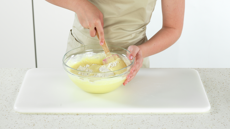 Ha i ca. halvparten av melblandingen, og vend det inn i eggedosisien. Bruk runde bevegelser med slikkepotten, og «hent» opp melet som har lagt seg på bunnen. Ikke rør for hardt, for å bevare luften som du har pisket inn i eggene.