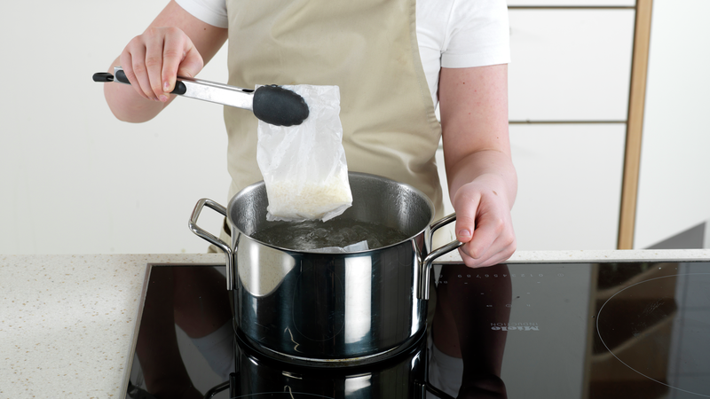Bruk en klype og legg posene med ris i vannet. Kok dem så lenge det står på pakken. Skru ned til middels varme, slik at det ikke koker over.