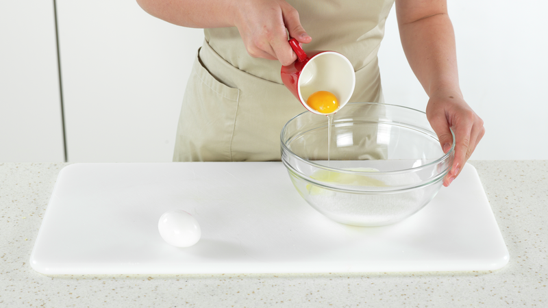 Mål opp sukker og ha i en bolle. Knekk så ett og ett egg i en kopp og ha det bollen. Å knekke det i en kopp først, gjør det enklere å ta ut eggeskall, hvis det kommer med.