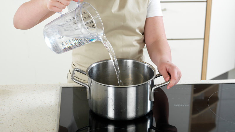 Sett en stor kjele på kokeplaten, bruk et målebeger eller en mugge og fyll kjelen halvfull med vann. Skru platen på fullt.