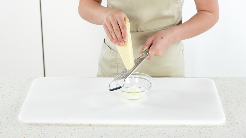 Nå skal du lage ostesaus. Du kan starte med å rive ost, hvis du ikke har ferdig revet. Du kan bruke parmesan, eller annen hvit ost. Legg osten i en liten skål eller bolle.