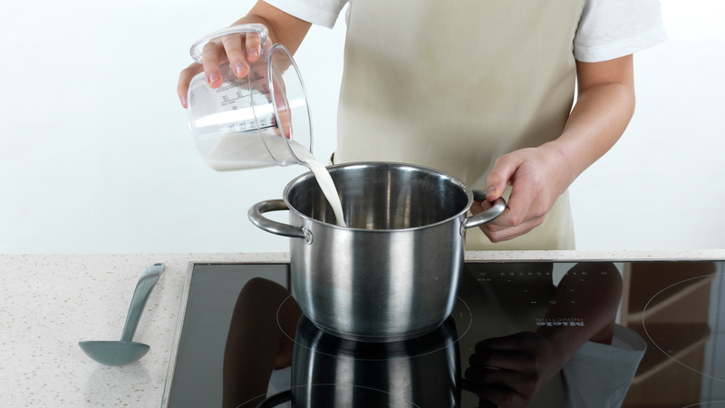 Mål opp melk og salt og ha i kjelen. Skru platen på høy varme og la det koke opp, mens du rører. Ikke gå fra kjelen når du gjør dette, da det fort kan koke over eller brenne seg.