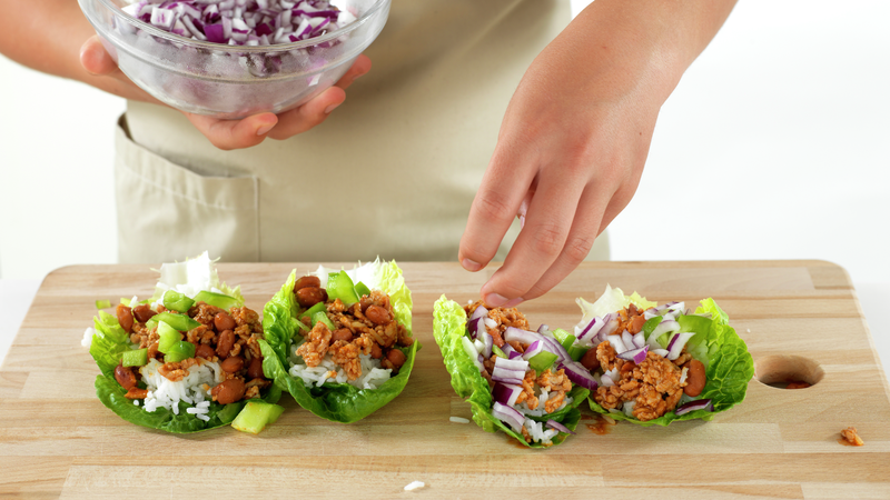 Fordel ris og kjøttblandingen på salatbladene. Strø over løk og paprika. Du kan også sette alt frem på bordet og la alle forsyne seg:)