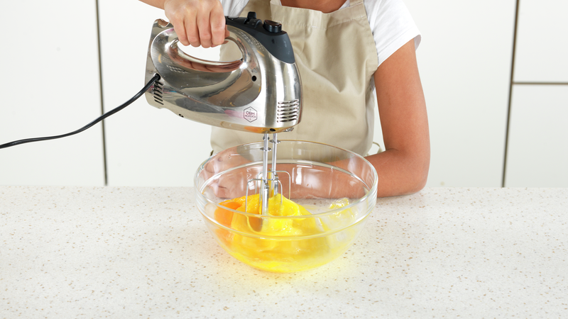 Sett stikkontakten til håndmikseren i støpselet. Pisk sammen sukker og egg med håndmikseren på høy hastighet, til det har blitt luftig eggedosis.
