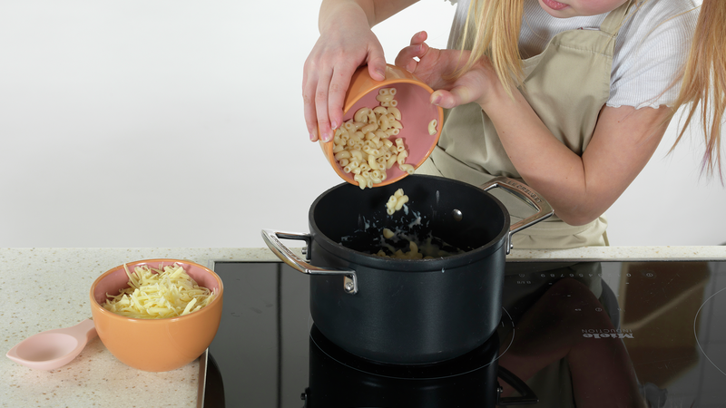 Mål opp kokt makaroni og revet ost i hver sin skål. Ha makaroni i kjelen. Hvis du ikke har ferdigkokt makaroni kan du også koke litt. Les på pakken hvordan det gjøres, eller sjekk ut en annen oppskrift med makaroni på MatStart.